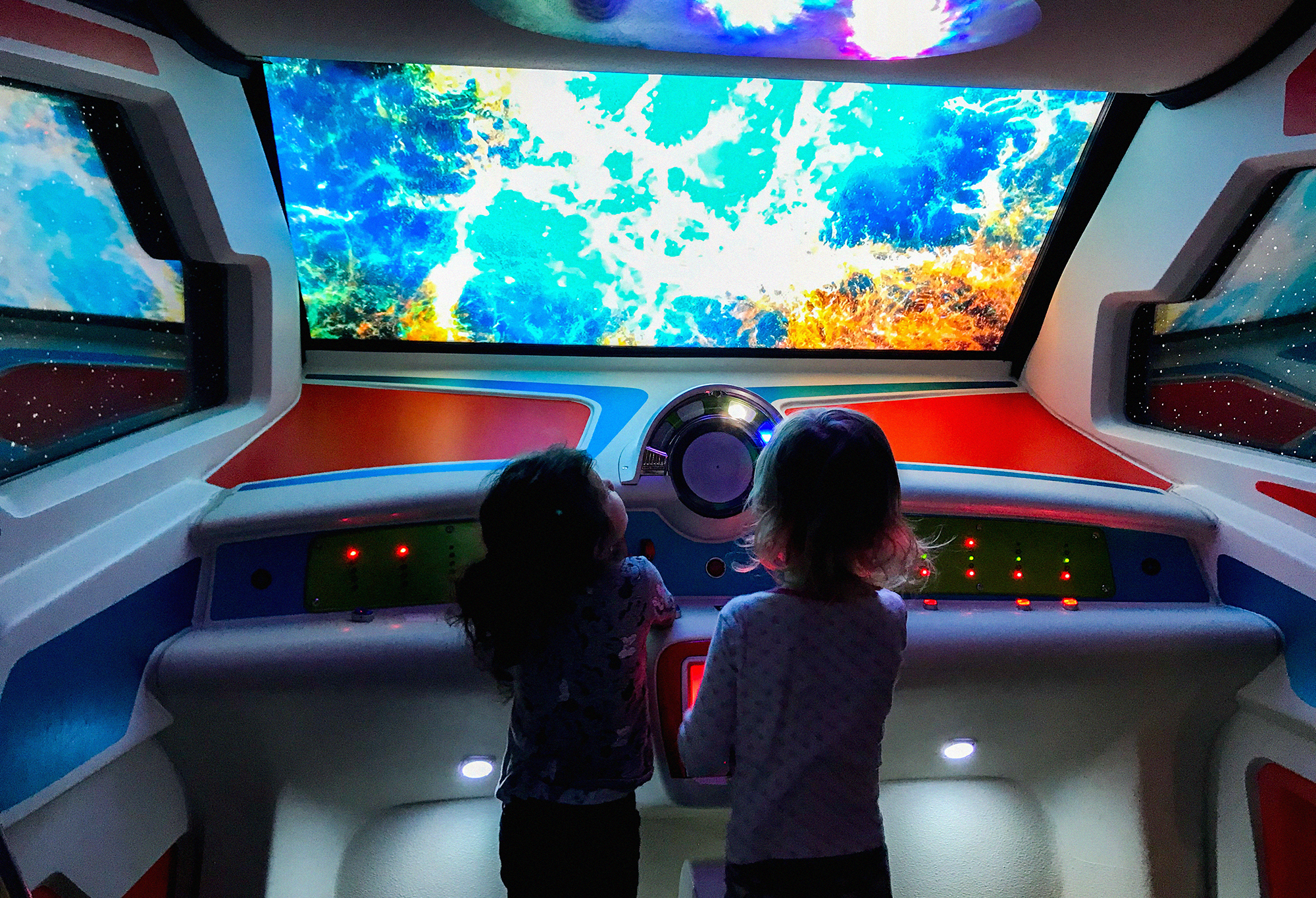 Two small children are playing inside a pretend spaceship